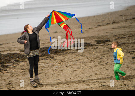 Aberystwyth Wales UK, giovedì 05 aprile 2018 UK Meteo: una donna e suo figlio divertiti a provare a volare un aquilone su un pomeriggio di caldo sole primaverile, con temperature in bassa teens centigradi, al mare in Aberystwyth sulla costa occidentale del Galles foto © Keith Morris / Alamy Live News Foto Stock