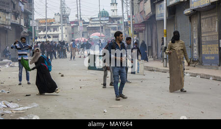 Srinagar, Jammu e Kashmir in India. 5 apr, 2018. Studente del Kashmir manifestanti scagliare pietre contro il governo indiano forze durante una manifestazione di protesta contro la recente assassinio dal governo indiano le forze attraverso la valle del Kashmir, a Srinagar, la capitale estiva di Indiano Kashmir amministrato, India. Pesanti scontri scoppiati tra gli studenti del Kashmir indiano e le forze governative in diverse parti di Srinagar il giovedì. Estrema violenza scoppiata dopo che gli studenti di diversi istituti educativi e inscenato proteste nel centro commerciale della città Lalchowk. Le autorità della parte precedente della giornata aveva ordinato Foto Stock