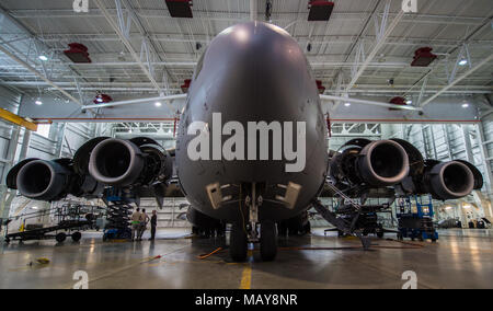 Una C-17 Globemaster III assegnato all'ala 176siede all'interno di un hangar per una stazione di casa controllare a base comune Elmendorf-Richardson, Alaska, Marzo 27, 2018. Il 3° e 176manutenzione squadrons completare un approfondito e quattro giorni di controllo programmato di un C-17 approssimativamente ogni 180 giorni. Una stazione di casa controllare è il dietro le quinte di manutenzione che possono impedire la perdita della vita, portare a risparmi in termini di tempo e denaro e di mantenere il velivolo adatta alla lotta. (U.S. Air Force foto di Senior Airman Curt Spiaggia) Foto Stock