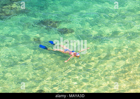 La donna lo snorkeling sulla barriera corallina in Hanauma Bay Nature Preserve, Oahu, Hawaii, Stati Uniti d'America. Femmina che giace al di sopra del cristallino in acqua di mare tropicale con bandiera americana bikini. Attività di sport acquatici nelle Hawaii. Foto Stock