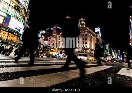 Tokyo, Giappone. Pedoni che attraversano la strada nel cuore del quartiere di Ginza a Tokyo. Ginza attraversando la notte. Moto sfocata. Foto Stock