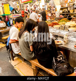 Seoul, Corea del Sud. Per coloro che godono di un fast food al mercato Gwangjang. Uno dei più popolari street food luogo dove è possibile acquistare kimbap, Foto Stock