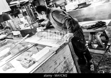 Tokyo, Giappone. Adulto lavoratore il taglio di tonno nel mercato del pesce Tsukiji al mattino presto. Foto Stock