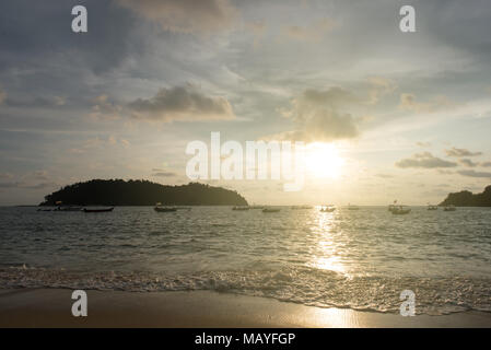 Vista di un Cielo di tramonto e silhouette di barche flottante e piccola isola sulla spiaggia come primo piano situato nell Isola di Pangkor, perak, Malaysia Foto Stock