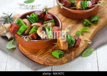 Lo spagnolo snack: Pincho Spiedini fritti con il salame chorizo, pimientos de padron e funghi Foto Stock