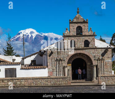 Prima chiesa coloniale costruita in Ecuador, con Vulcano Chimborazo in background e il blu del cielo Foto Stock