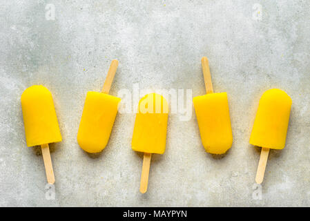 In casa popsicles con succo di arancia, ghiaccioli su bastoni, vista dall'alto lay piatto Foto Stock