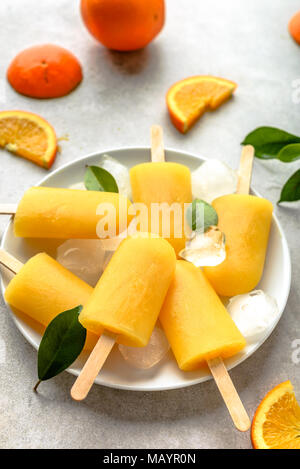 Orange popsicles con ghiaccio e succo di frutta, estate cibo rinfrescante Foto Stock