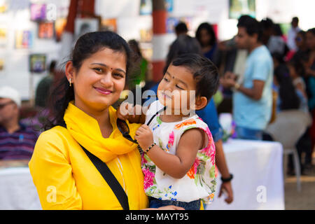 Giovane donna con sua figlia sorridente alla fotocamera, Imperatrice giardino a Pune Foto Stock