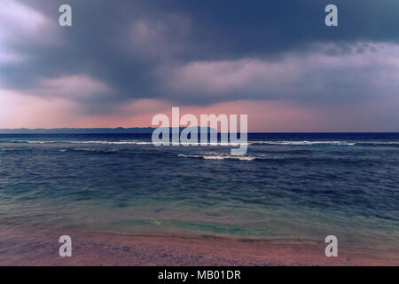 Bel tramonto sul mare irrequieto. Nuvoloso viola il cielo blu e acqua trasparente. Mare prima della tempesta. I raggi del sole che passa attraverso la tempesta Foto Stock