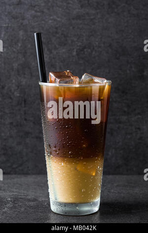 Caffè ghiacciato in vetro su pietra nera. Foto Stock