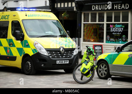 Medico di tre veicoli parcheggiati insieme, un ambulanza van, una bicicletta e un auto medica frequentare un emergenza in Kingston. Foto Stock