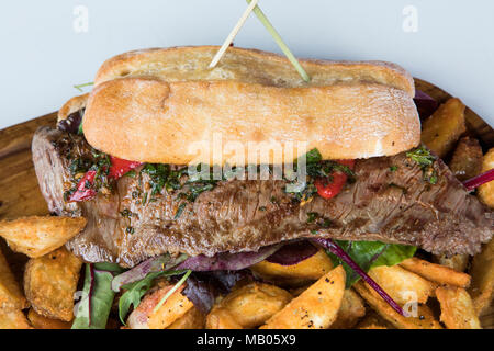 Minuto steak sandwich su baguette con chip, pepe e contorno di insalata. Foto Stock