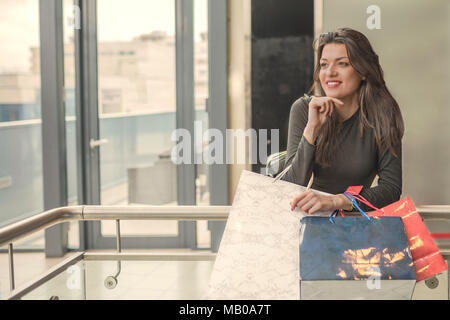 Ragazza sorridente con borse per lo Shopping nel Centro Commerciale per lo shopping. Shopping Moda ragazza ritratto. La bellezza della donna con borse per lo Shopping nel Centro Commerciale per lo shopping. Shopper. Le vendite. Sh Foto Stock