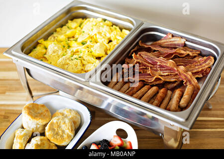 La prima colazione a buffet con uova strapazzate, salsicce e bacon Foto Stock