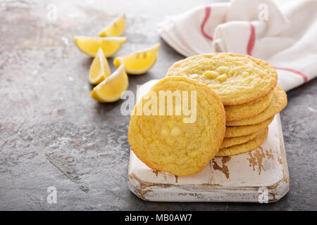 I cookie di limone con gocce di cioccolato bianco impilati su una scheda Foto Stock
