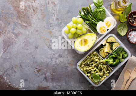 Pasto vegetariano contenitori prep con uova e pasta verde con pesto e verdure Foto Stock