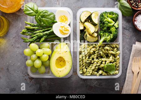 Pasto vegetariano contenitori prep con uova e pasta verde con pesto e verdure Foto Stock