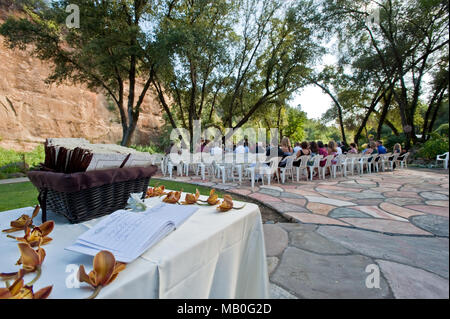 Un matrimonio all'aperto sotto ombrosi alberi di quercia nella parte anteriore di un fiume in corrispondenza di una sede in California, con un guest book tabella in primo piano Foto Stock