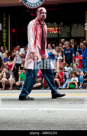 Atlanta, GA, Stati Uniti d'America - 31 agosto 2013: una sanguinosa zombie medico mette in pericolo la folla a guardare il drago con sfilata passano su Peachtree Street. Foto Stock