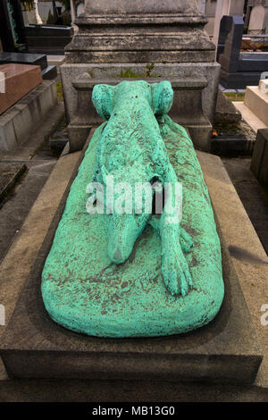 Statua di cane in appoggio sulla tomba presso il Cimitero di Passy, Parigi, Francia Foto Stock