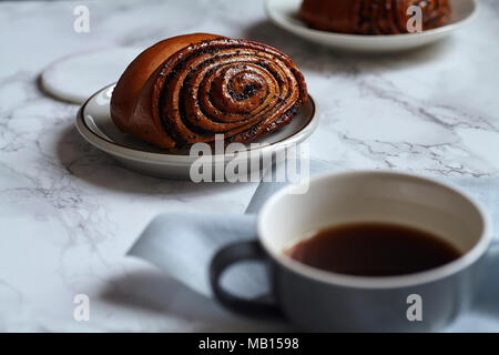 La prima colazione con dolci panini con semi di papavero sulla tavola di marmo Foto Stock