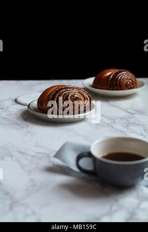 La prima colazione con dolci panini con semi di papavero sulla tavola di marmo Foto Stock