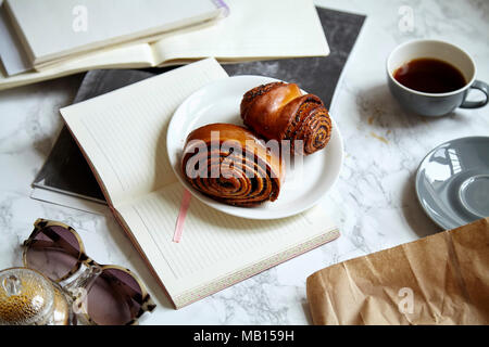 Tettuccio di colpo di panini dolci con semi di papavero sulla tavola di marmo impilati con i materiali di studio Foto Stock