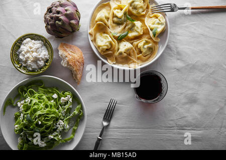 Immagine di overhead di italiano tradizionale di ravioli con ricotta e spinaci tagliatelle servito con un bicchiere di vino Foto Stock