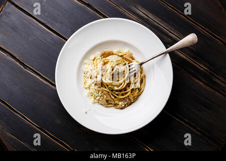 Pasta Spaghetti con funghi porcini e formaggio parmigiano sulla piastra su legno sfondo tabella Foto Stock