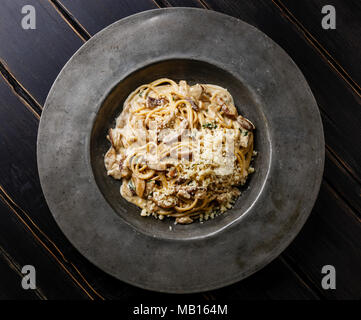 Pasta Spaghetti con funghi porcini e formaggio parmigiano sulla piastra su legno sfondo tabella Foto Stock