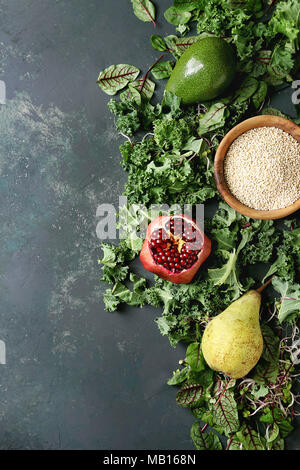 Insalata verde e frutta mix per insalata di cavolo riccio, giovani foglie di bietola, germogli, pera, avocado, melograno, ciotola di materie non cotti quinoa oltre il testo scuro Foto Stock