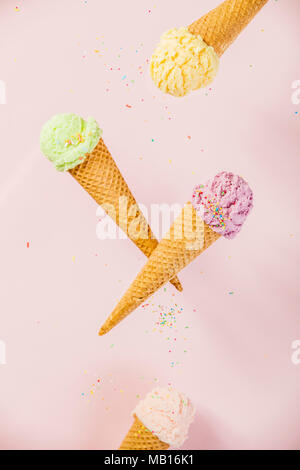 Coloratissimo gelato in una cialda di rocche su sfondo rosa Foto Stock