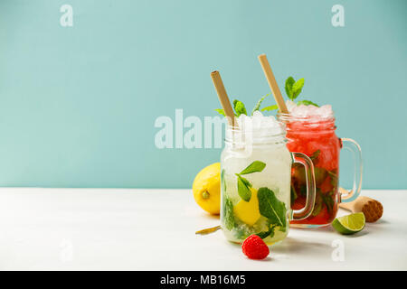 Fresco cocktail bevande con ghiaccio e frutta decorazione di erbe. Bevande non alcoliche bere-bevanda. Il Mojito su sfondo blu Foto Stock