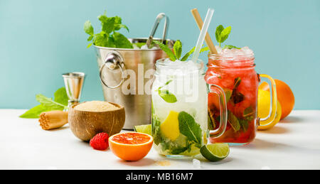 Fresco cocktail bevande con ghiaccio e frutta decorazione di erbe. Bevande non alcoliche bere-bevanda. Il Mojito su sfondo blu Foto Stock