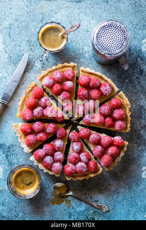 Appena sfornato crostata di crema decorate con lamponi freschi su un tavolo Foto Stock