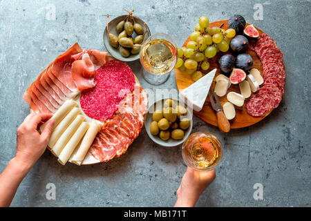Piatto di antipasti e due bicchieri di vino bianco sul tavolo Foto Stock