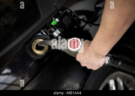 La mano di riempire il serbatoio con gasolio a un self-service di stazione di gas Foto Stock