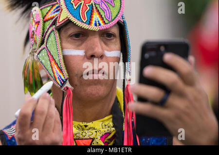 Il Veterano dell'esercito, Brian Hammill della nazione Ho-Chunk, applica la faccia della vernice prima di grand entry al ventottesimo annuale Museo sentito nel Campionato del Mondo Hoop dance contest presso l'Heard Museum in Phoenix, Arizona nel febbraio 10, 2018. Nella pubblica Native American hoop performance di danza, ballerini può utilizzare fino a 50 cerchi di fare formazioni che quando combinati trasportano una storia. Foto Stock