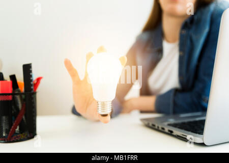 Business donna, designer la mano che tiene la lampadina di luce, il concetto di nuove idee e innovazione e creatività. Foto Stock