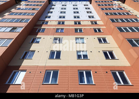 Vista della parte frontale di un edificio con appartamenti da terra con cucina di finestre e balconi che mostra simmetricamente sul lato destro e sinistro Foto Stock