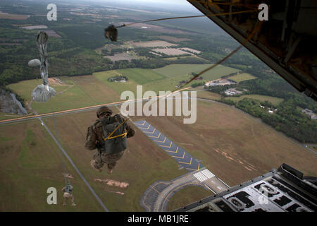 Avieri dalla base 820th gruppo di difesa salta da un HC-130J contro il re II durante static-line jump proficiency training, Marzo 30, 2018 nei cieli di Moody Air Force Base, Ga. Il 820th BDG e la 71st RQS lavorano insieme spesso così i difensori e l'equipaggio possono mantenere le loro qualifiche. (U.S. Air Force photo by Staff Sgt. Ryan Callaghan) Foto Stock