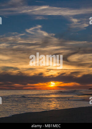 Tramonto con il fuoco nel cielo - Isola di Smeraldo Beach North Carolina. Vedere la bellezza del cielo come le nuvole si raccolgono nel dipinto di rosso, arancione, rosa, incandescente Foto Stock