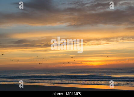 Tramonto con il fuoco nel cielo - Isola di Smeraldo Beach North Carolina. Vedere la bellezza del cielo come le nuvole si raccolgono nel dipinto di rosso, arancione, rosa, incandescente Foto Stock