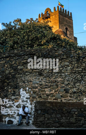 Gondar, Etiopia - Gennaio 17, 2018: un uomo Etiope seduto alla Fasilides cancello di Castello. È stato designato come un Sito Patrimonio Mondiale dell'UNESCO in Gondar. Foto Stock