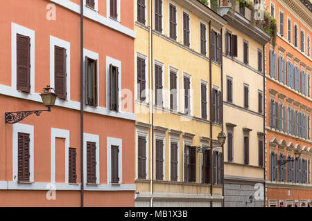 Sfumature di arancione e giallo adornano le pareti di edifici colorati per le strade di Roma, Italia. Foto Stock