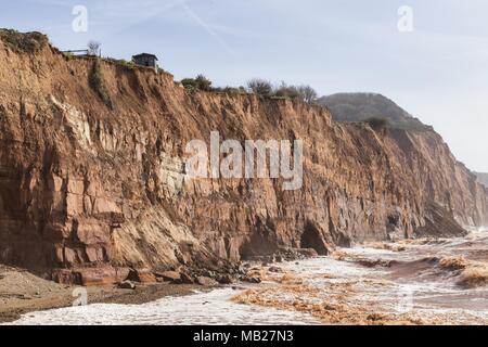 Sidmouth, 6th Apr 18. Un residente del Devon ha divertente mettere un avviso "for sale" sul suo capannone – come ora è arroccato pollici da una caduta di 100 piedi. Quattro cascate scogliera nella scorsa settimana hanno lasciato proprietà in Cliff Road, Sidmouth manca metri di giardino. La continua erosione di Pennington Point, ad est della città di Regency, ora mette in pericolo la foce del fiume Sid stesso, che se colpito potrebbe inondare una grande area della città. I costi di riparazione sono stimati a £72 milionse l'alluvione si è verificata. Foto Stock