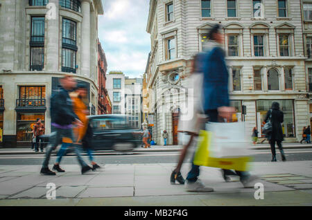 Moto acquirenti sfocata camminando giù high end di Londra high street Foto Stock