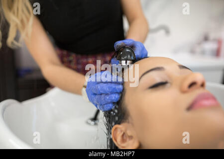 Close up ritratto di donna rilassato dopo aver lavato i capelli al parrucchiere Foto Stock