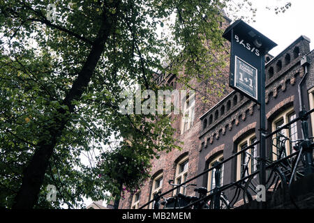 Utrecht, Paesi Bassi - 13 agosto 2016: castello cittadino Oudaen visto dal molo lungo la Oudegracht. In primo piano un albero e biciclette parcheggiate in Foto Stock